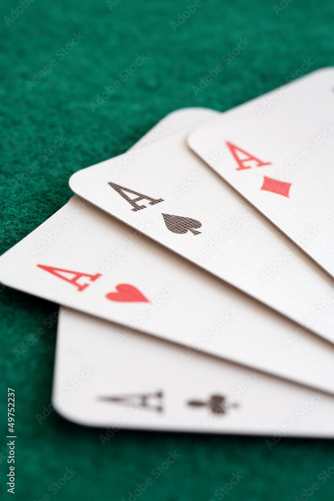 Close-up of four playing cards showing aces.