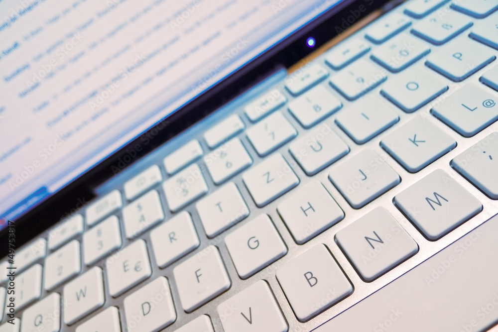 Tastatur eines Computers vor Bildschirm Tastatur eines Computers vor Bildschirm