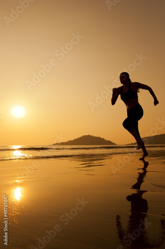 Silhouette of a woman running on th beach.