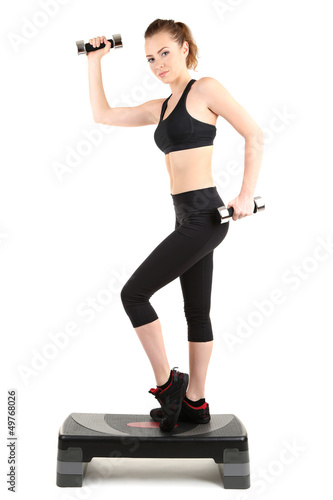 Young woman doing fitness exercises on stepper isolated on