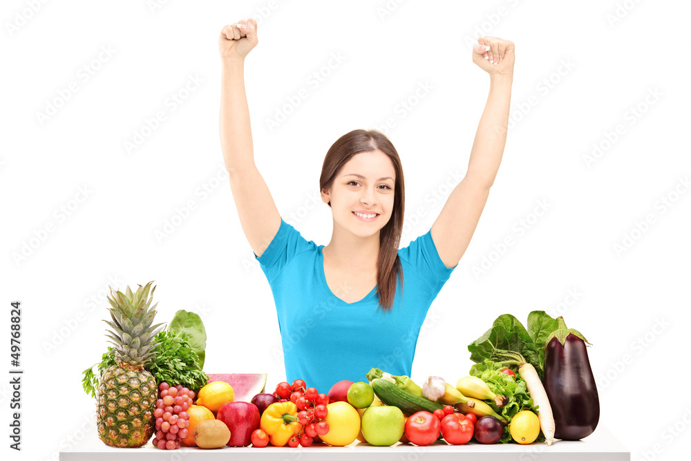 Beautiful young female gesturing happiness on a table full of fr Beautiful young female gesturing happiness on a table full of fr