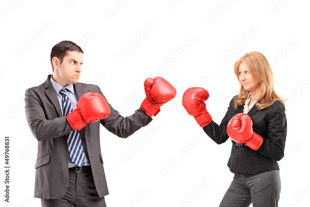 Businesswoman with boxing gloves having a fight with a young bus Businesswoman with boxing gloves having a fight with a young bus