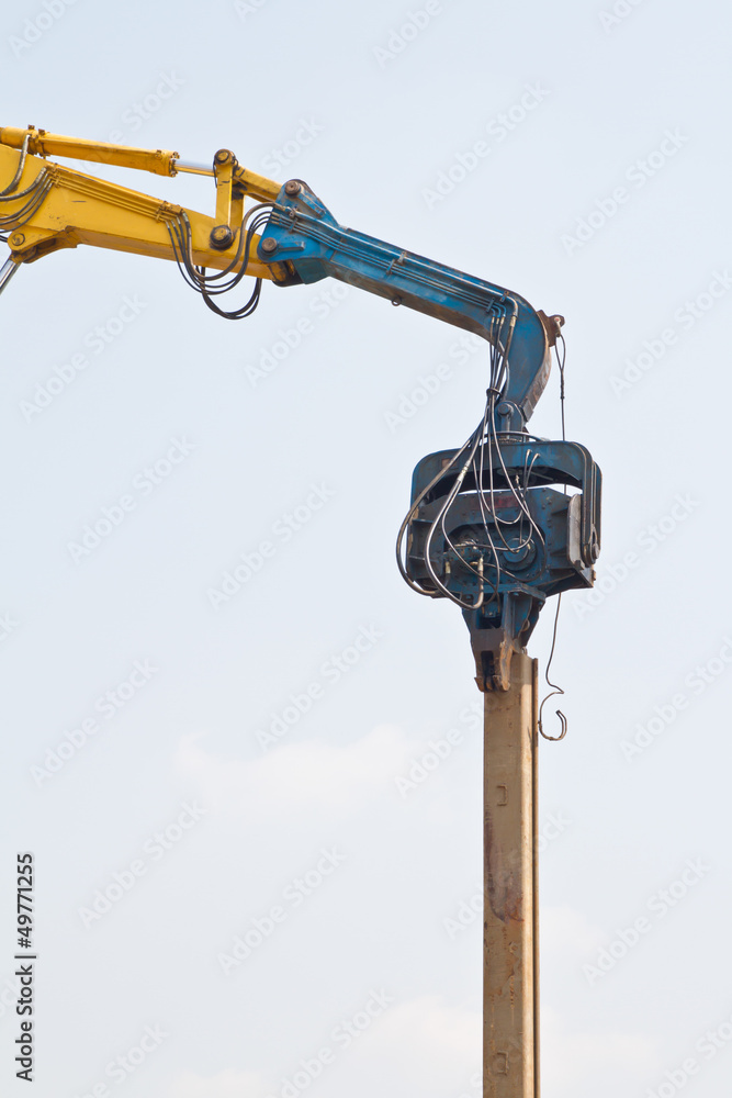 Backhoe is lacing sheet pile at river side Backhoe is lacing sheet pile at river side