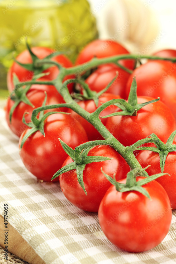 Red ripe cherry tomatoes on a vine on a kitchen towel Red ripe cherry tomatoes on a vine on a kitchen towel