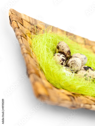 Easter quail eggs are on braided plate with sisal 
