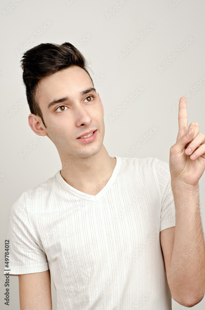 Look at this! Young man smiling pointing up. Look at this! Young man smiling pointing up.