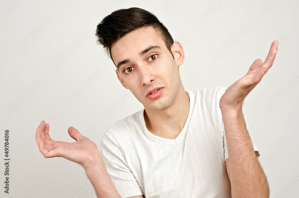 Young man raising his hands wondering...