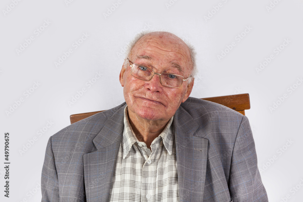 portrait of elderly smart confident man sitting in his armchair portrait of elderly smart confident man sitting in his armchair
