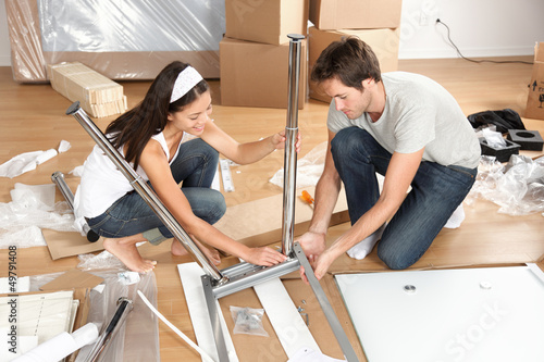 Couple moving in together assembling furniture table