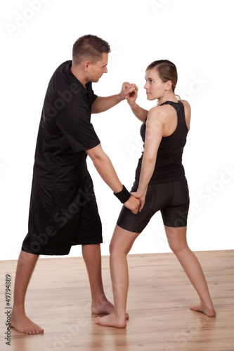 Young man practicing fighting sport with a woman