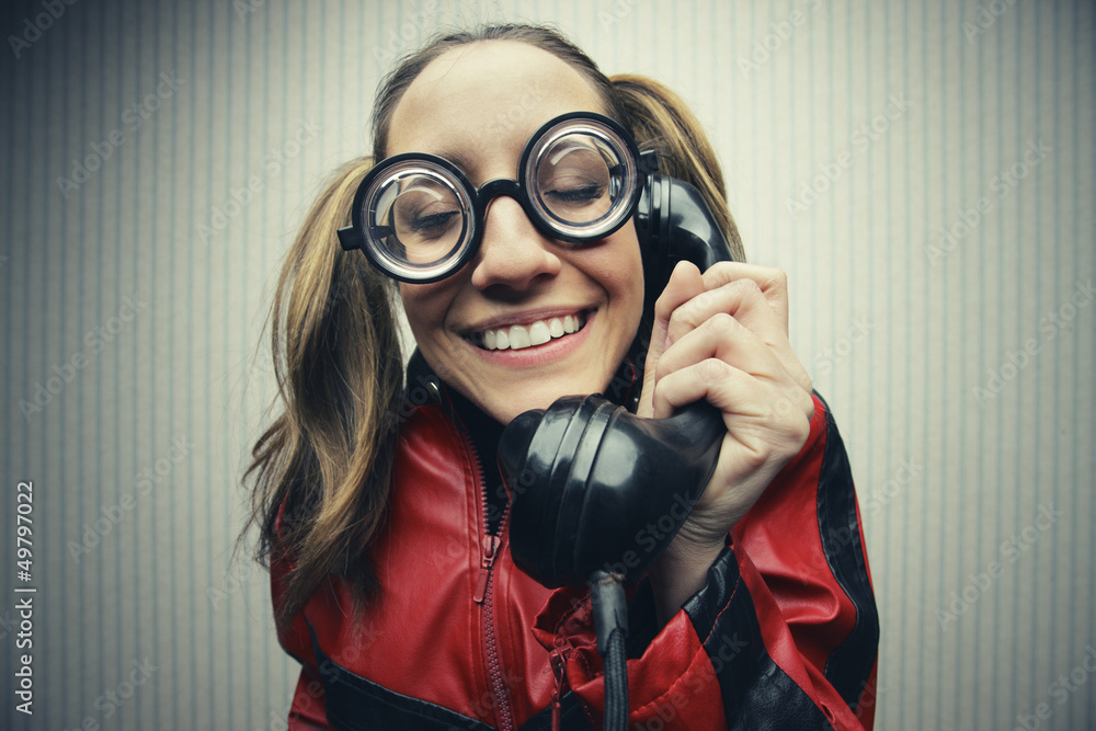 Nerdy woman speaking on a black rotary vintage phone