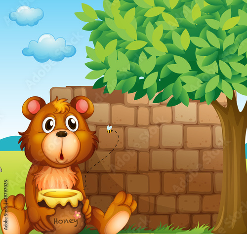 A bear with honey near a pile of bricks