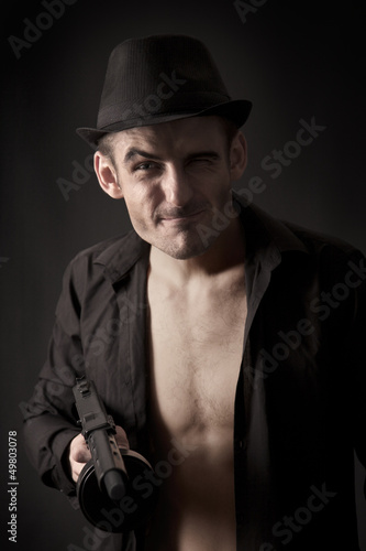 Gangster with a tommy gun grimacing isolated on black
