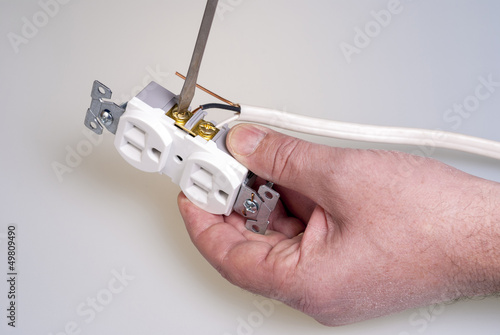 Wires are screwed into an electrical socket
