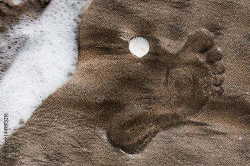 Footprint and seashell on a beach near Ngwe Saung in Myanmar photo