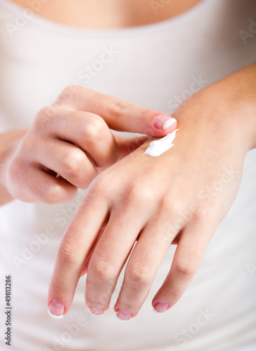 Body care. Woman applying cream on hands