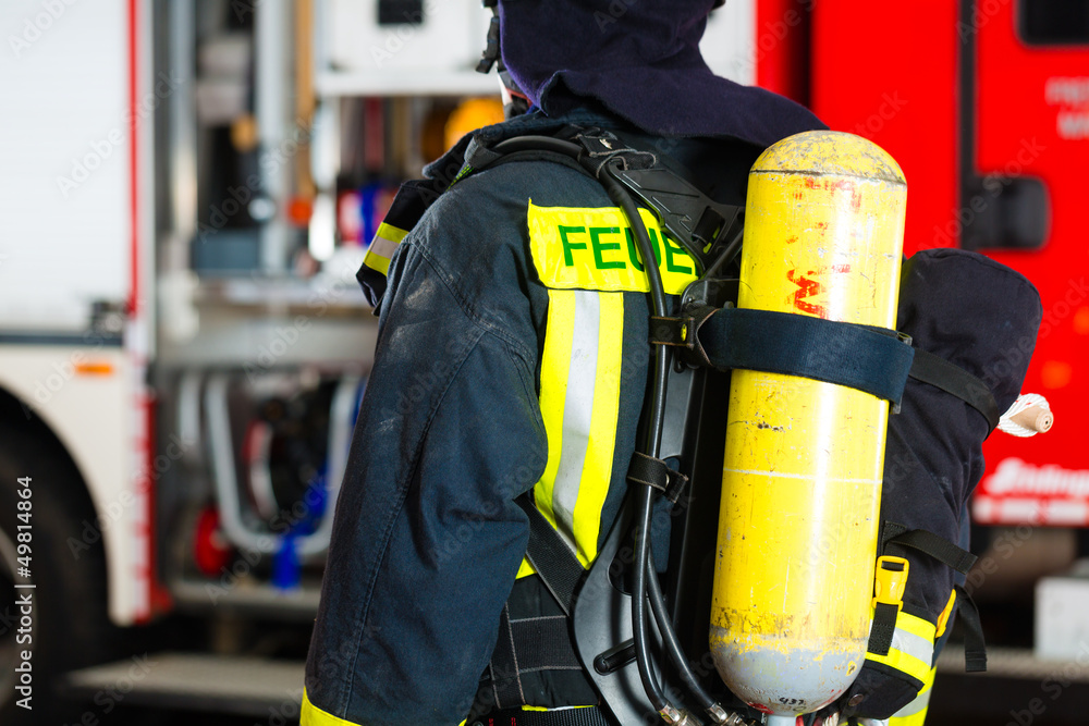 Feuerwehrmann steht in Uniform vor einer Feuerwehr Feuerwehrmann steht in Uniform vor einer Feuerwehr