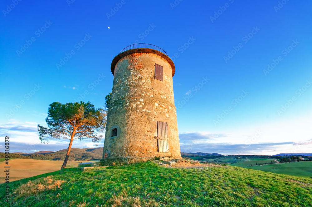 Tuscany, Maremma sunset landscape. Rural tower and tree on hill.