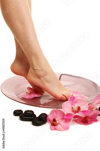 Female feet in spa bowl with water, isolated on white © Africa Studio