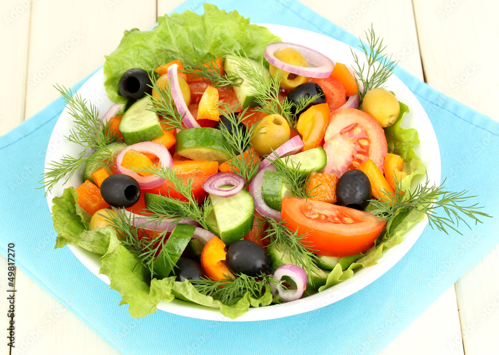 Fresh salad in plate on wooden table Fresh salad in plate on wooden table