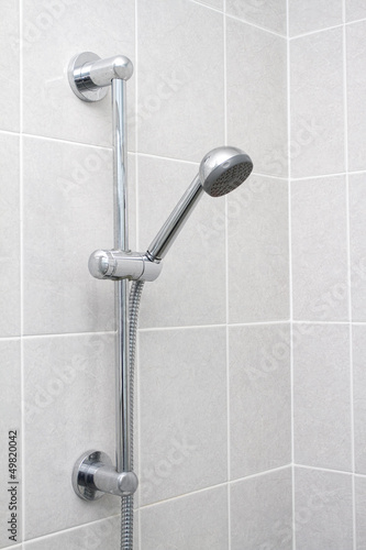 Chrome showerhead and rail on grey tiles