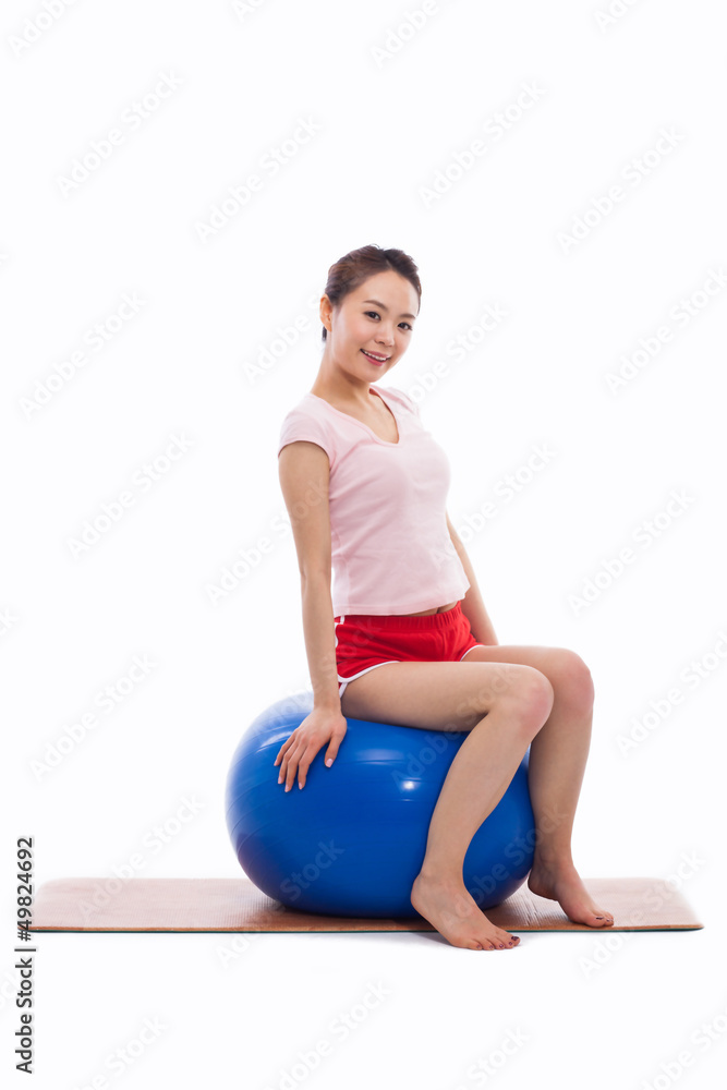Fototapeta premium Young woman with gym ball isolated on white