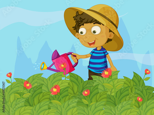 A boy watering the plants in a garden