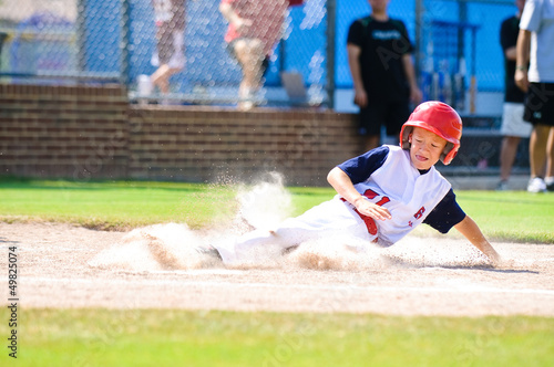 Photography Little league baseball player sliding home.