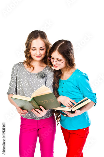 Two little beautiful girl reading a book