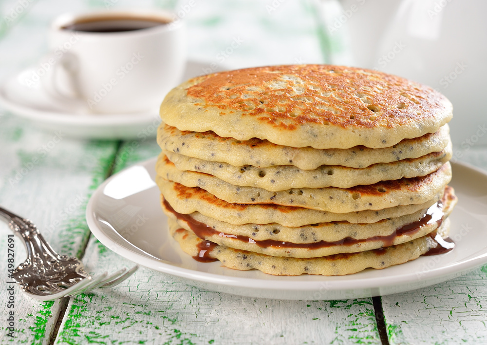 Pancakes with poppy seeds on a white table Pancakes with poppy seeds on a white table