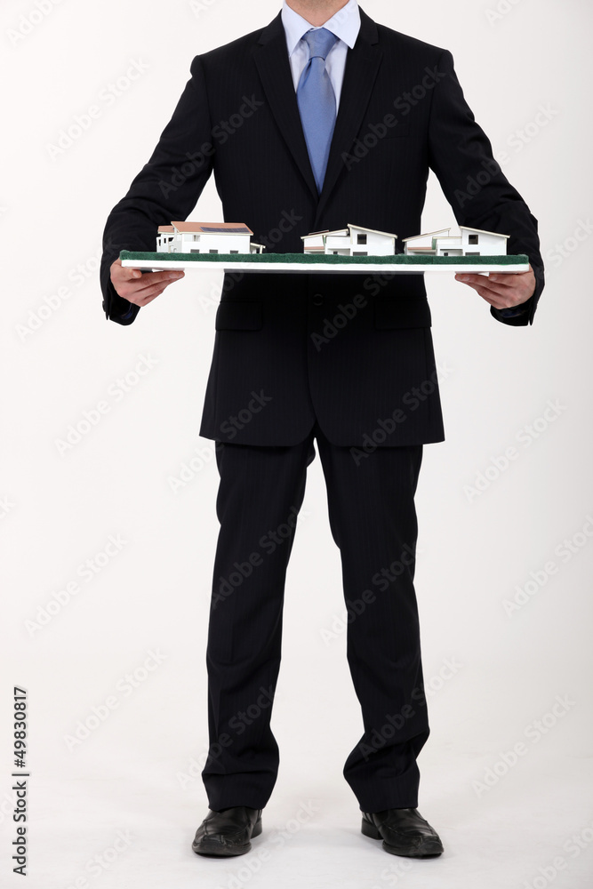 Businessman holding a model of a housing estate Businessman holding a model of a housing estate
