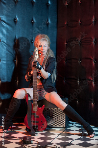 blonde girl with a guitar on a dark background
