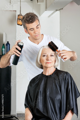 Woman With Hairdresser Styling Hair At Salon