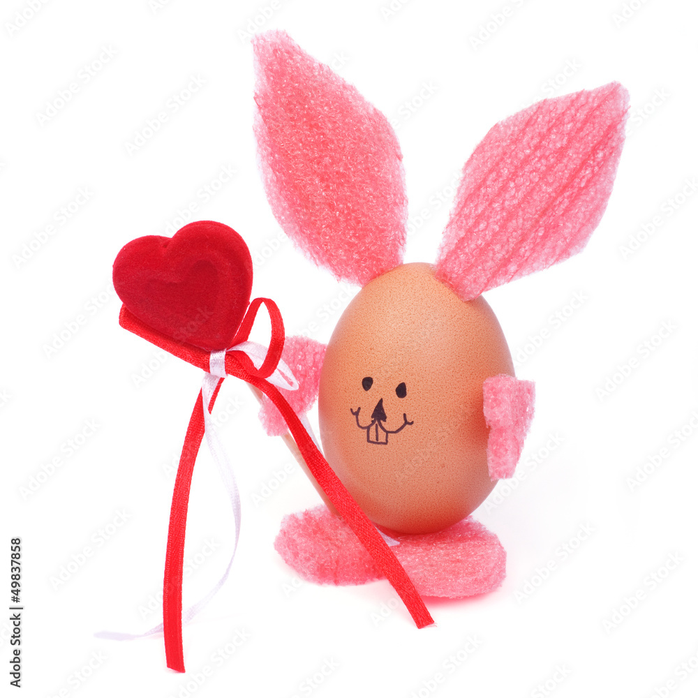 Rabbit with a heart shaped easter eggs isolated