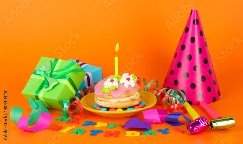 Colorful birthday cake with candle and gifts