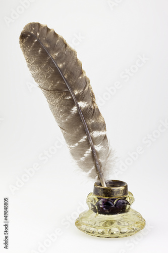 antique glass inkwell and old pen isolated background