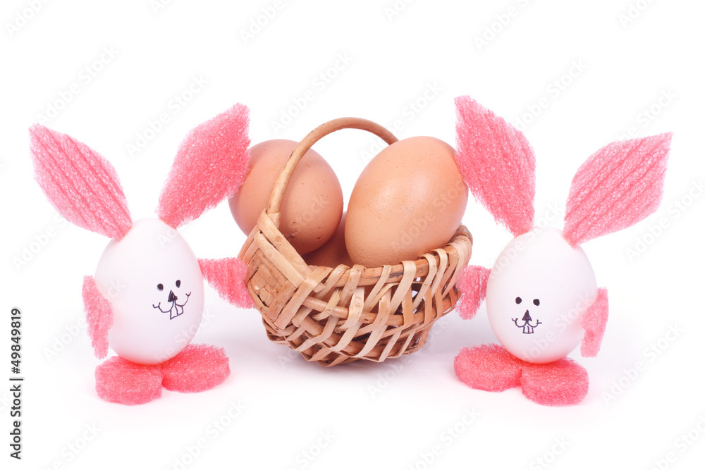 basket with Easter eggs and two rabbits isolated on white