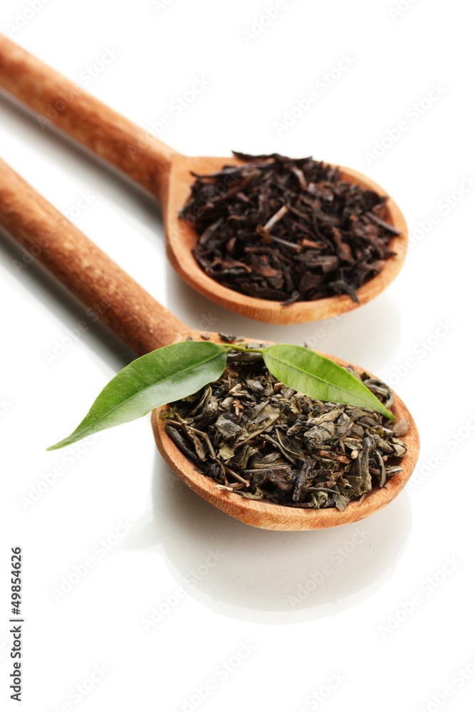Dry tea with green leaves in wooden spoons, isolated on white Dry tea with green leaves in wooden spoons, isolated on white