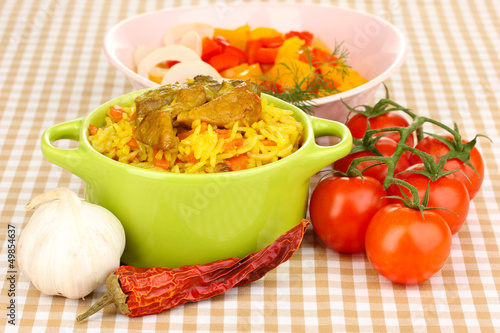 Delicious pilaf with vegetables on tablecloth background