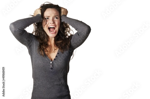 Frustrated and angry woman is screaming and pulling her hair