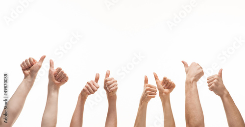 Many hands showing thumb up signs on white background