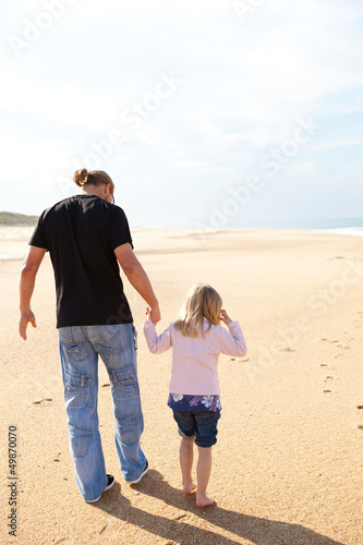 Father and daughter walking at the beach