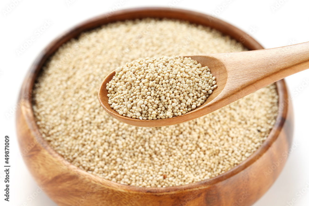 uncooked quinoa in the wooden bowl and spoon uncooked quinoa in the wooden bowl and spoon