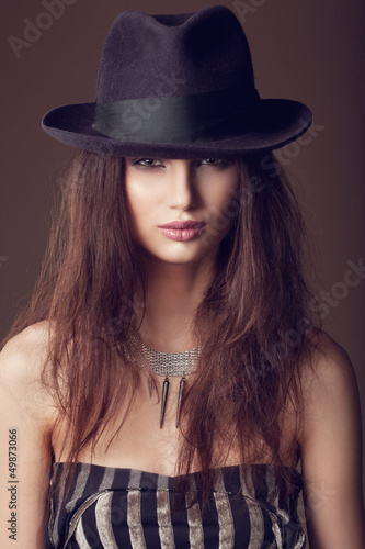 Woman with open lips in black hat on dark background © Kaponia Aliaksei