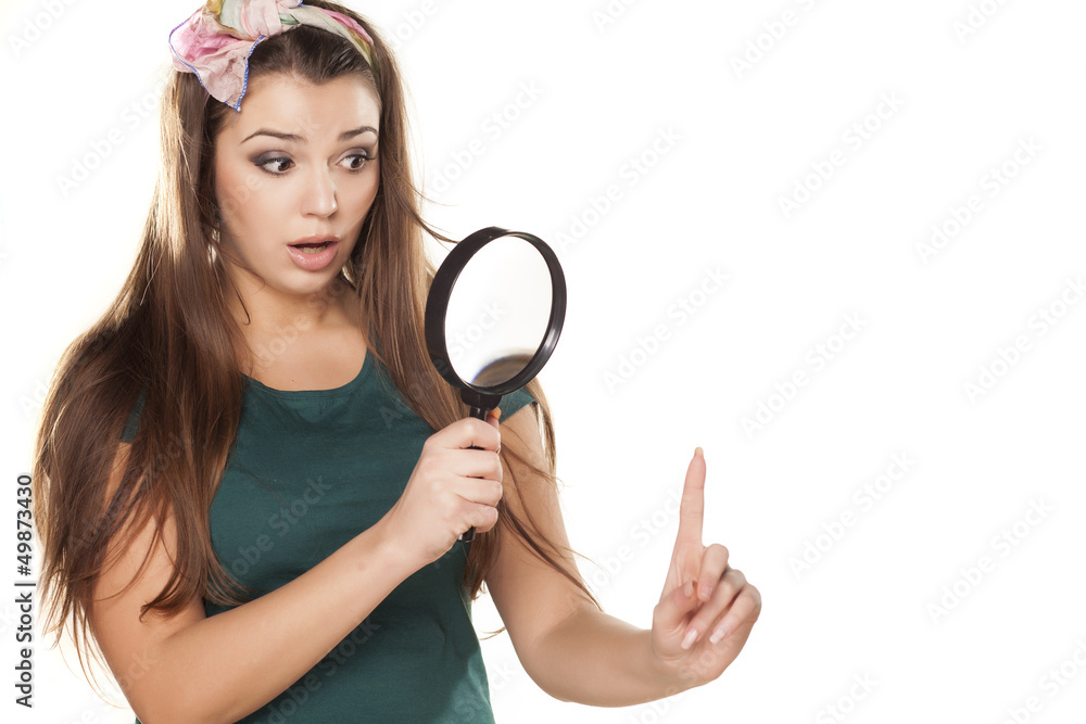 surprised beautiful girl looking at her finger through the lens surprised beautiful girl looking at her finger through the lens