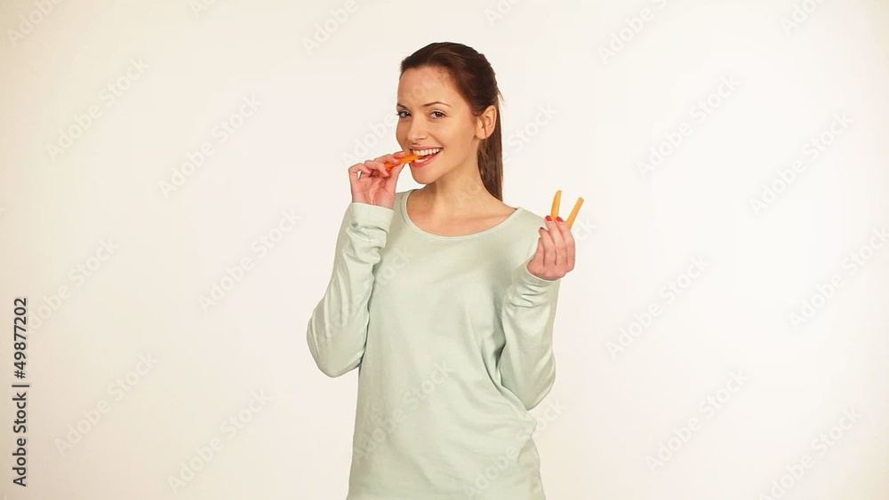 Hübsche junge Frau isst eine Möhre Hübsche junge Frau isst eine Möhre