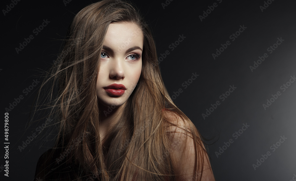 Portrait of a beautiful young woman in a red dress. Portrait of a beautiful young woman in a red dress.