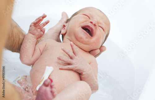 newborn is bathed in the bathroom