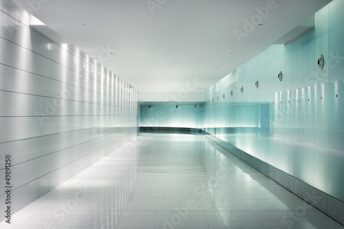Back-lighted glass walls in an underground futuristic corridor