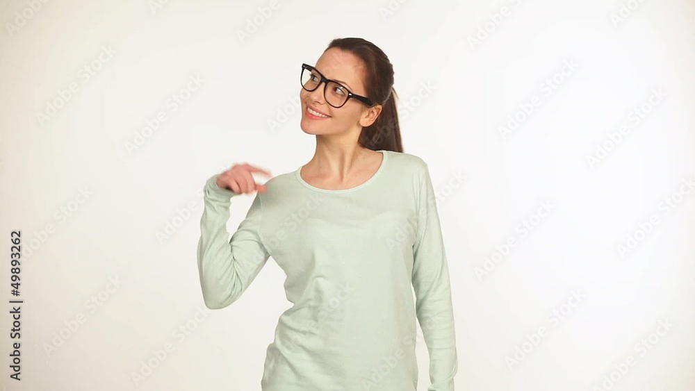 Gutaussehende junge Frau mit schwarzer Brille zeigt nach oben